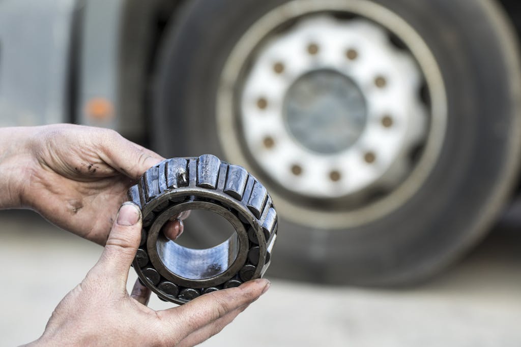 mechanic holding a bearing of the hub of the truck
